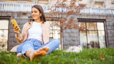 Nainen rentoutumassa ulkona ruoholla ilman kenkiä