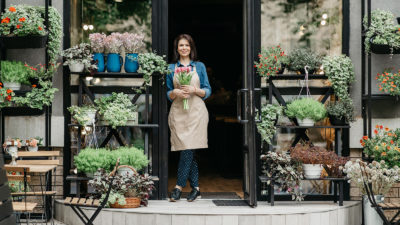 Paikallinen markkinointi on paikallisille yrityksille välttämätöntä – kuvassa nainen kukkakauppansa edessä